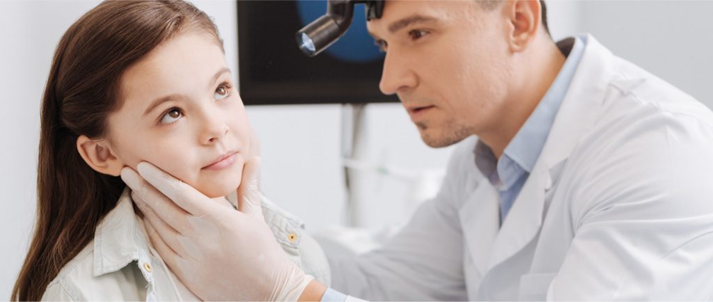 ENT specialist examining a child's ear